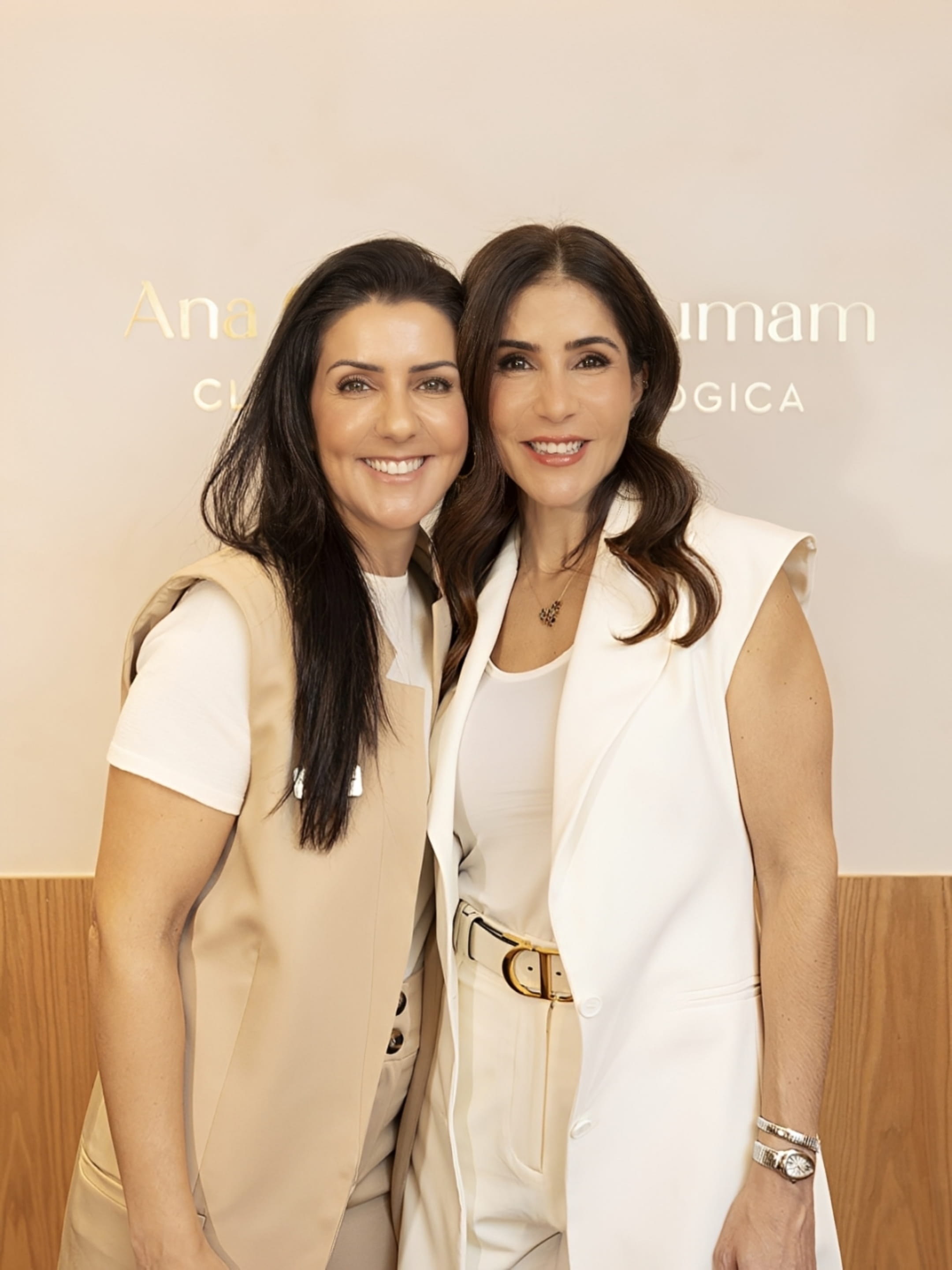 Duas integrantes da clínica sorrindo na recepção